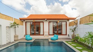 A modern house with a swimming pool, two blue bean bag chairs, and a wooden fence. - Casa Lova - Luxury 2 BR Villa with Pool (Munggu)