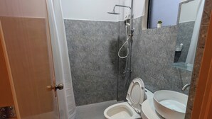 A bathroom with a toilet, sink, shower, and a small window. - The Canyoneer Inn (Alegria)