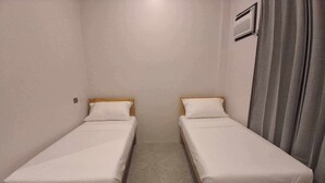 A room with two single beds, each with a wooden frame and white bedding. - The Canyoneer Inn (Alegria)