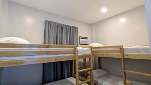 A bunk bed room with a window, curtains, and a heater. - The Canyoneer Inn (Alegria)