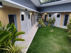 Ein modernes Hotelinnere mit Innenhof, mehreren Türen und Kübelpflanzen.