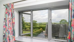 A room with a large window overlooking a rural landscape. - Fell View Cottage (Kendal)