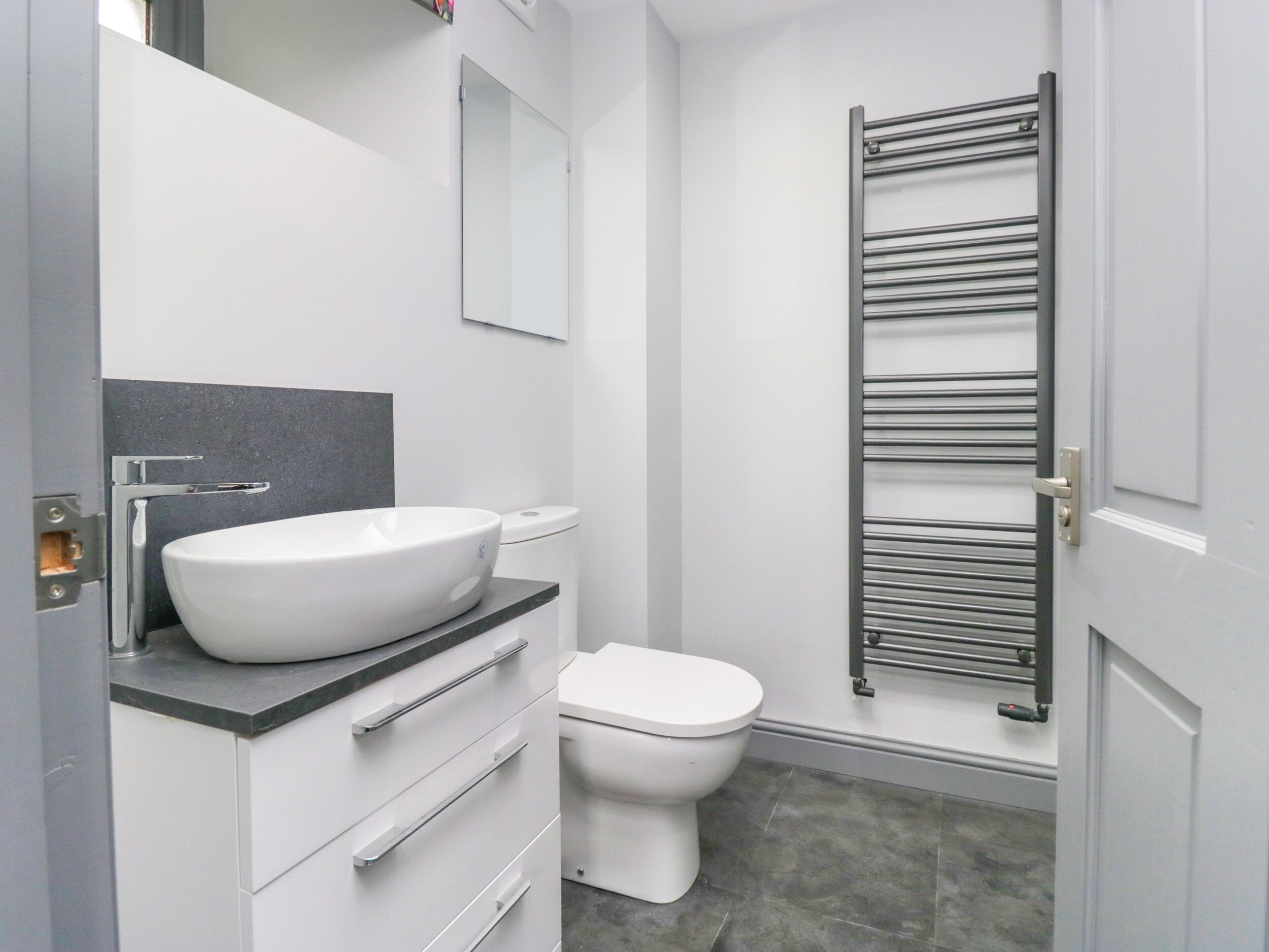 Ein modernes Badezimmer mit Waschbecken, Toilette und Handtuchhalter.