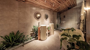 A modern bathroom with a wooden ceiling, two round mirrors, a bathtub, and a sink. - La Sen Village (Nam Hoa Lu)