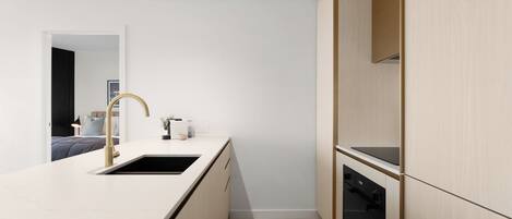 Una cocina moderna con un lavaplatos integrado, lavavajillas y armarios de madera.