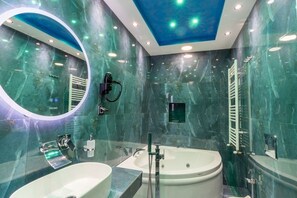 Un baño moderno con un espejo grande, una bañera y un lavabo.