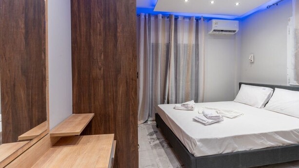 Un dormitorio moderno con una cama, muebles de madera y un equipo de aire acondicionado.