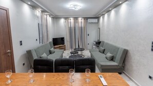 Una sala de estar moderna con un sofá, una mesa de centro y un televisor.