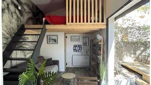 A modern interior with a wooden staircase, a loft area, and a view of the outdoors. - Maisonnette and terrace in the heart of the village to do everything on foot in St Mandrier (Saint-Mandrier-sur-Mer)