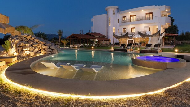 Un complexe hôtelier moderne doté d’une piscine, de chaises longues et d’un jacuzzi.