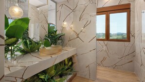 Une salle de bain avec un mur en marbre, une fenêtre en bois et une plante posée sur le comptoir.