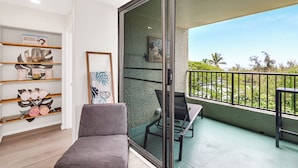 A balcony with a view of palm trees and a clear sky.
