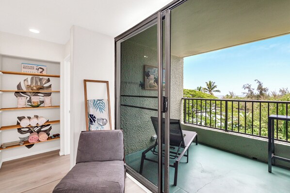 A balcony with a view of palm trees and a clear sky.