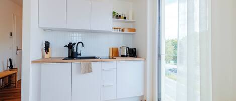 Fridge, stovetop, dishwasher, coffee/tea maker