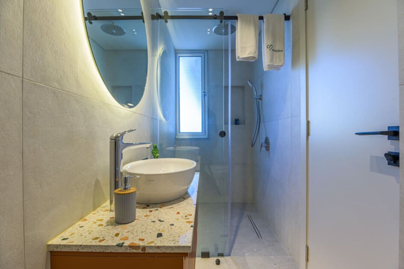 Une salle de bain moderne avec une baignoire sur pieds, une douche à parois de verre et un grand miroir.