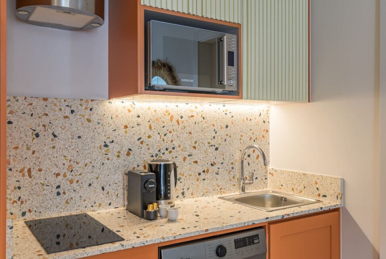A kitchen with a countertop, a microwave, a toaster, and a sink.