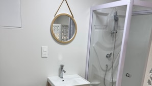 Et badeværelse med toilet, håndvask og bruser.
