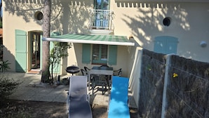 A building with a tiled roof, a balcony, and a door.