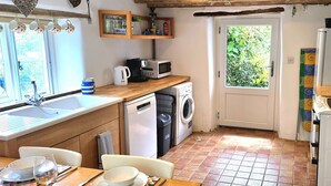 A compact kitchen with a sink, microwave, and washing machine.