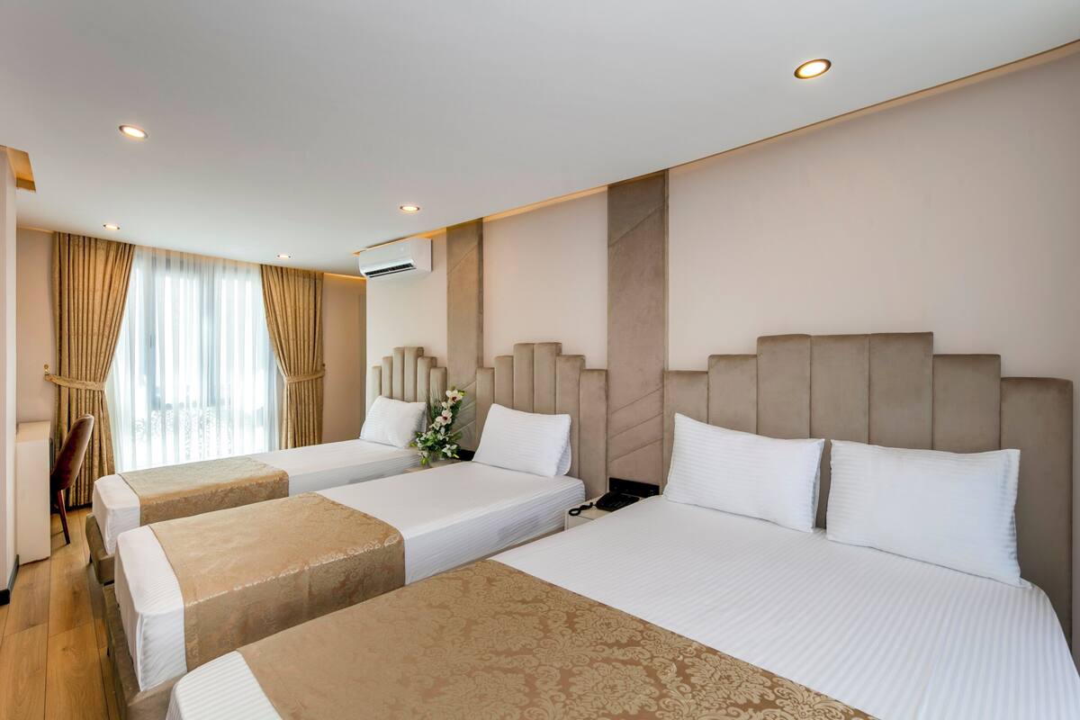 Ein Hotelzimmer mit zwei Betten, einem Schreibtisch und einem Stuhl.