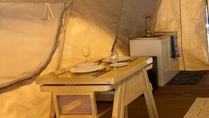 A tent with a dining table set for two, a small kitchenette, and a window. - Reef Resort Unit B8 (Island Garden City Of Samal)
