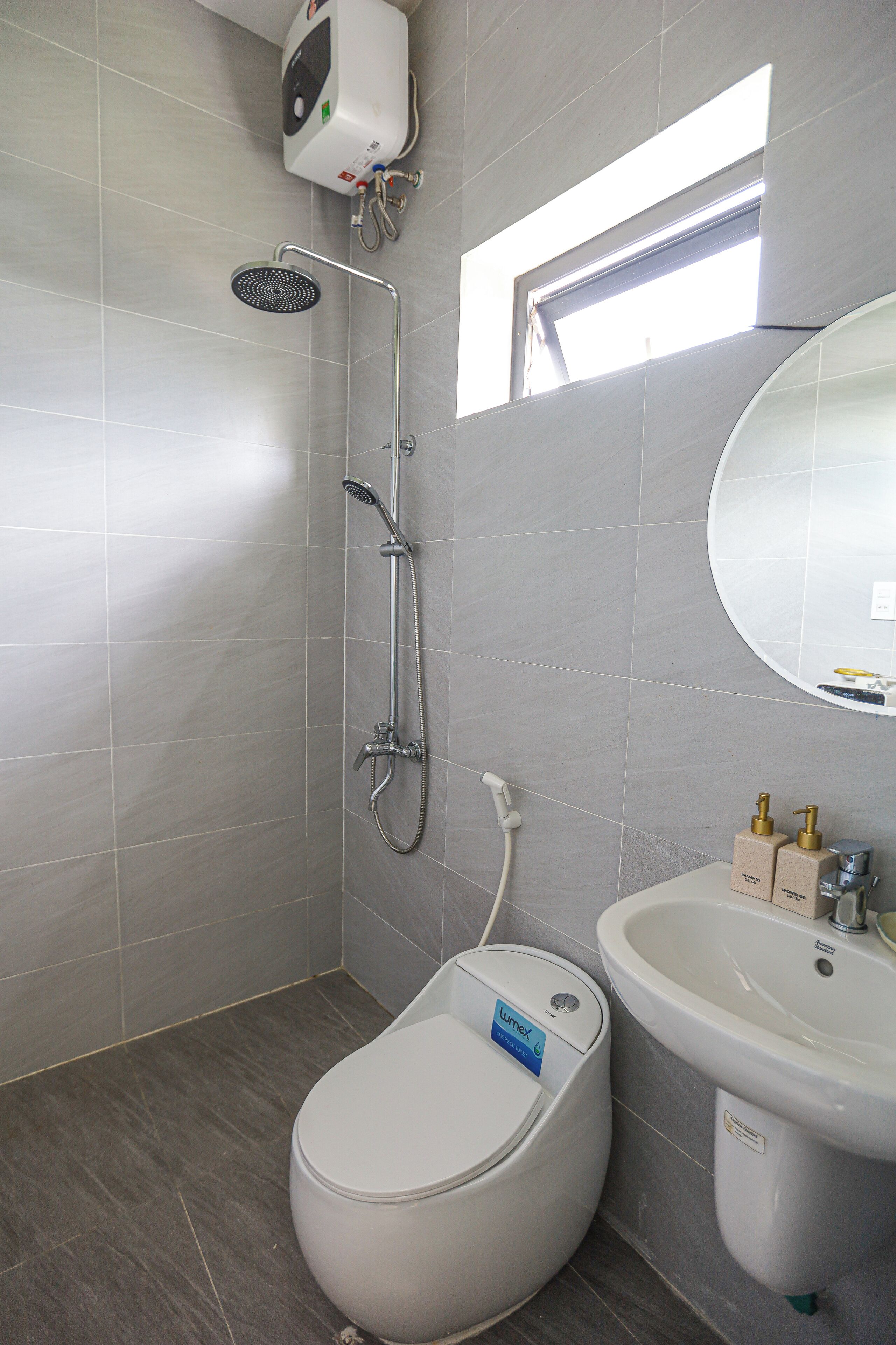 A modern bathroom with a toilet, sink, and shower.