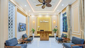 Vestíbulo de hotel con mostrador de recepción, zona de estar y detalles decorativos.