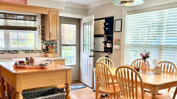 Una cocina con armarios de madera, una mesa de comedor con sillas y una isla de cocina con cestas.