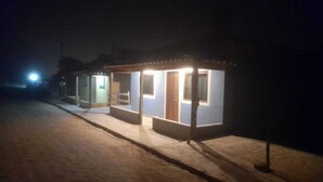 Un petit bâtiment d’un seul étage, doté d’un porche abrité et de quelques fenêtres, éclairé par un éclairage artificiel la nuit.