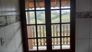 Une pièce dotée d’une fenêtre à cadre en bois donnant sur un balcon agrémenté d’une balustrade.