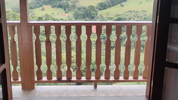 Un balcon donnant sur un paysage verdoyant.
