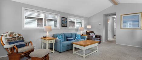 A living room with a blue sofa, wooden armchair, and a coffee table.