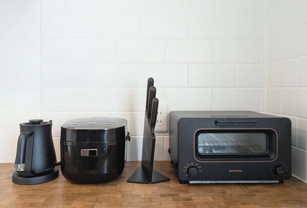 Una cocina con cafetera, olla de cocción lenta y horno tostador.