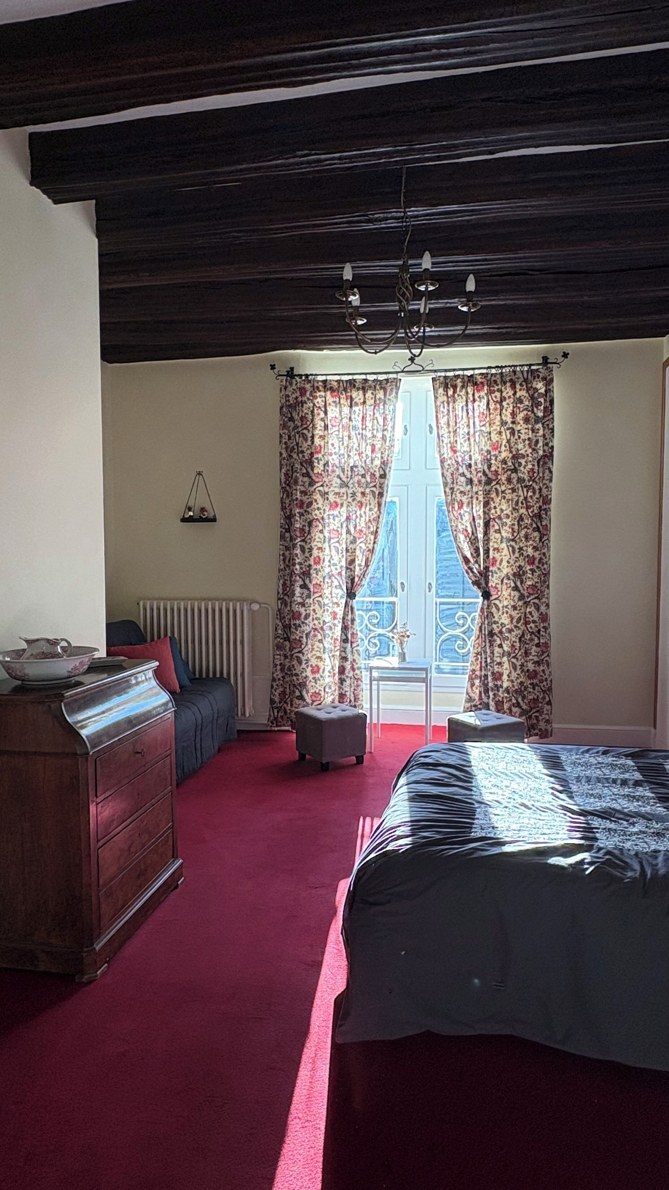 Un dormitorio con cama, cómoda y radiador.