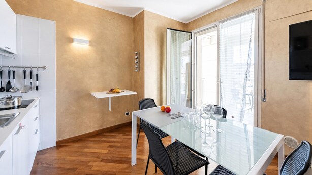 A modern kitchen with white cabinets and a stainless steel sink. - Charming Apartment Genova City View (Genoa)
