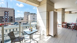 A balcony with a table and chairs, a view of the city, and a building with 'VIGILI DEL FUOCO' signage. - Charming Apartment Genova City View (Genoa)
