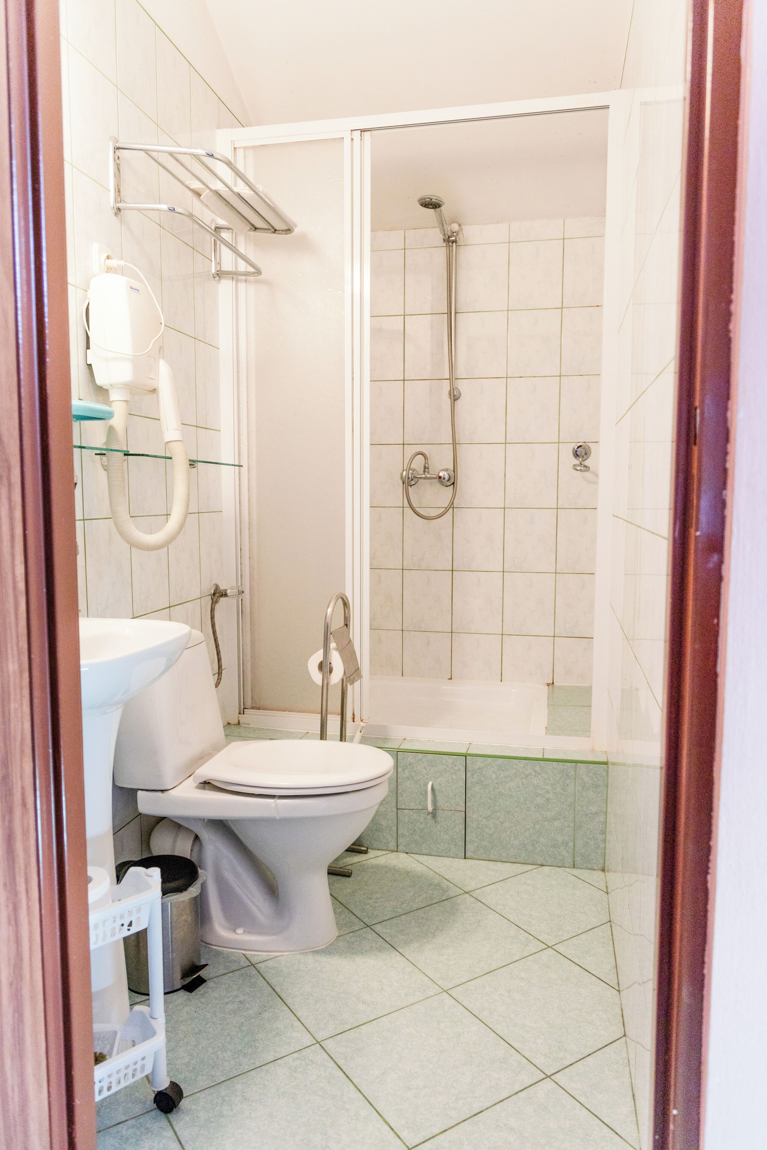 A bathroom with a toilet, sink, and shower.