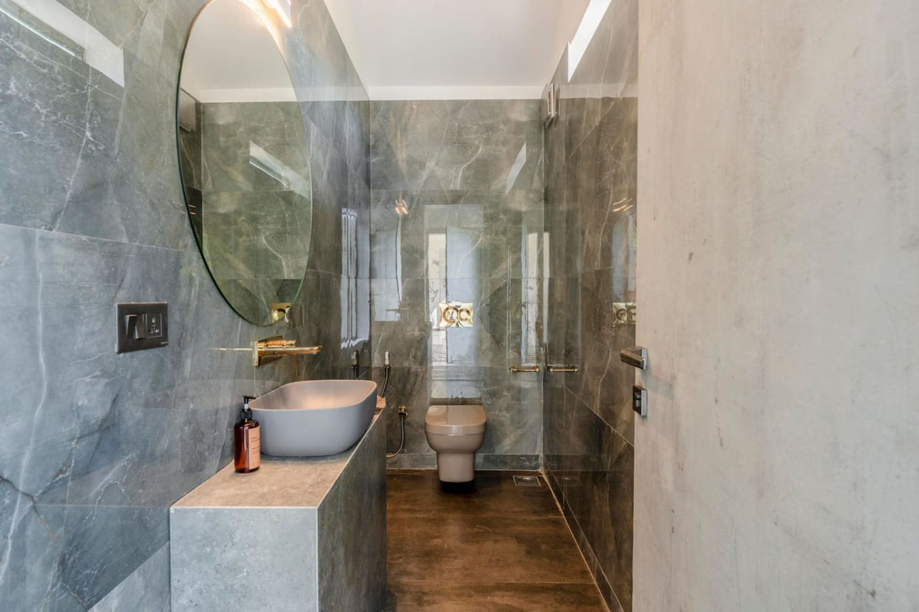 Une salle de bain moderne avec une baignoire sur pieds, des toilettes et un grand miroir.