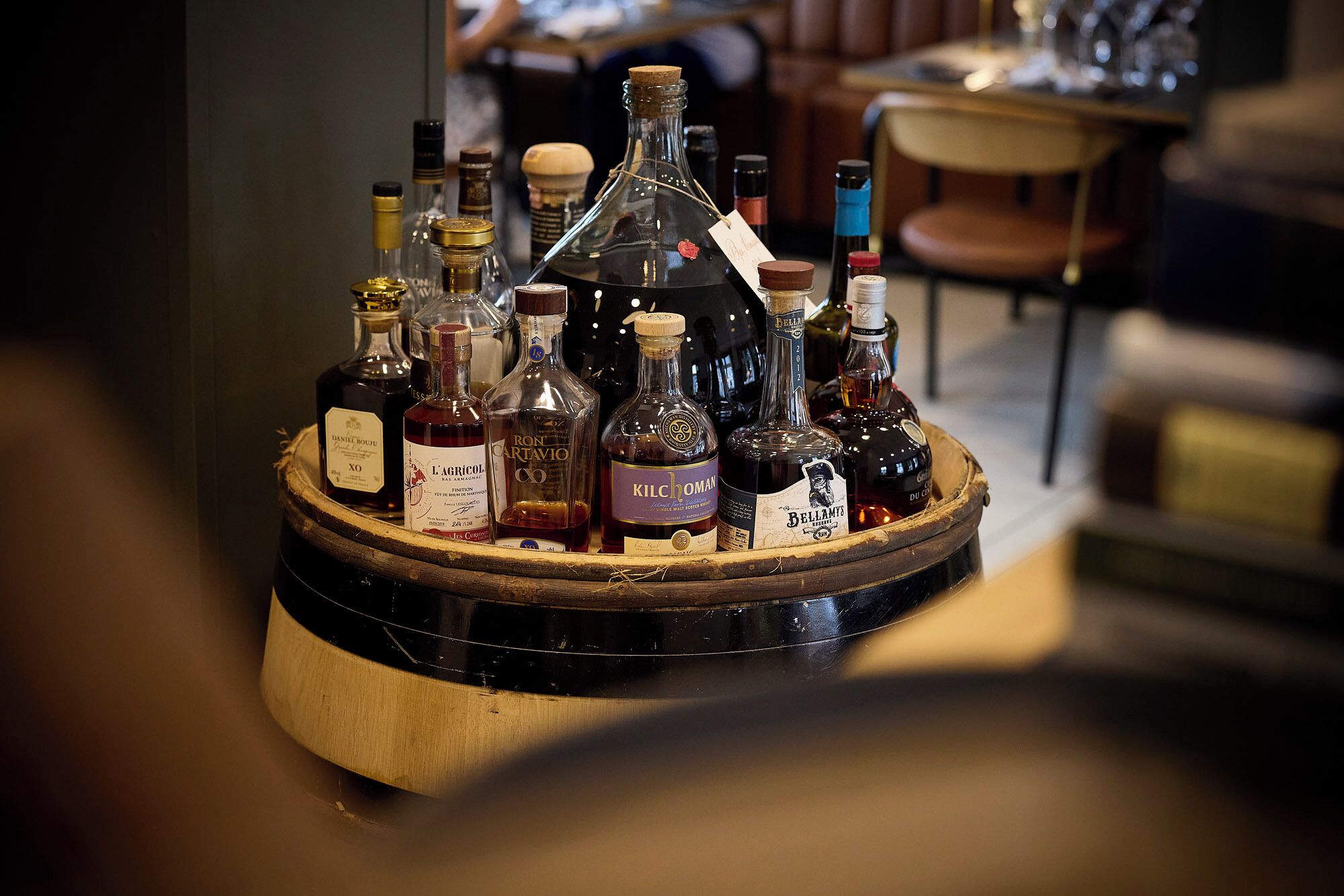 Variedad de botellas sobre una bandeja de madera, probablemente con licores o vinos.