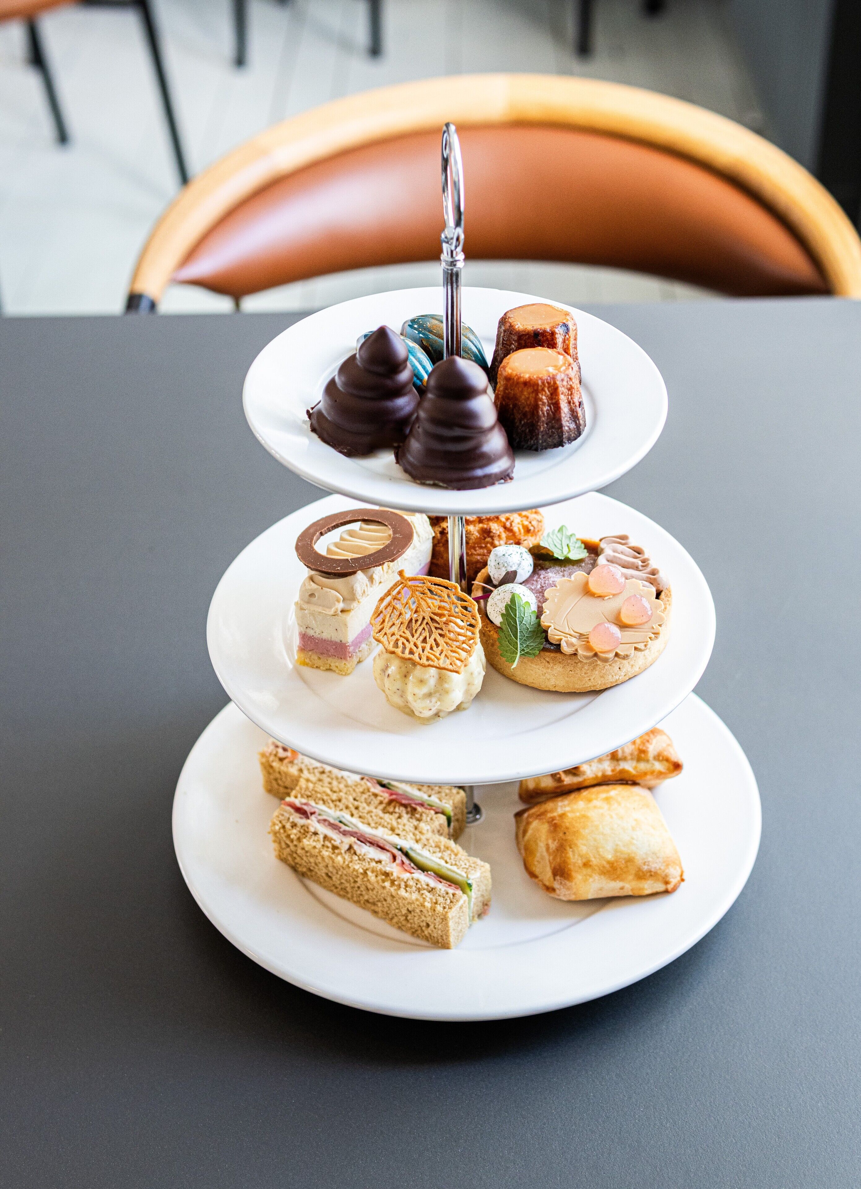 A three-tiered dessert stand with various pastries and desserts.