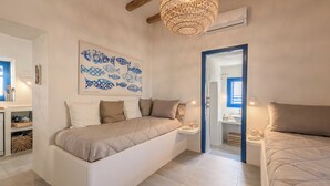 Un dormitorio moderno con una cama grande, mesitas de noche, aire acondicionado de pared y un cuadro decorativo de peces.