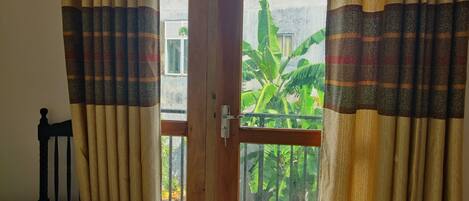 A room with a wooden door, a white table, and curtains with a striped pattern.
