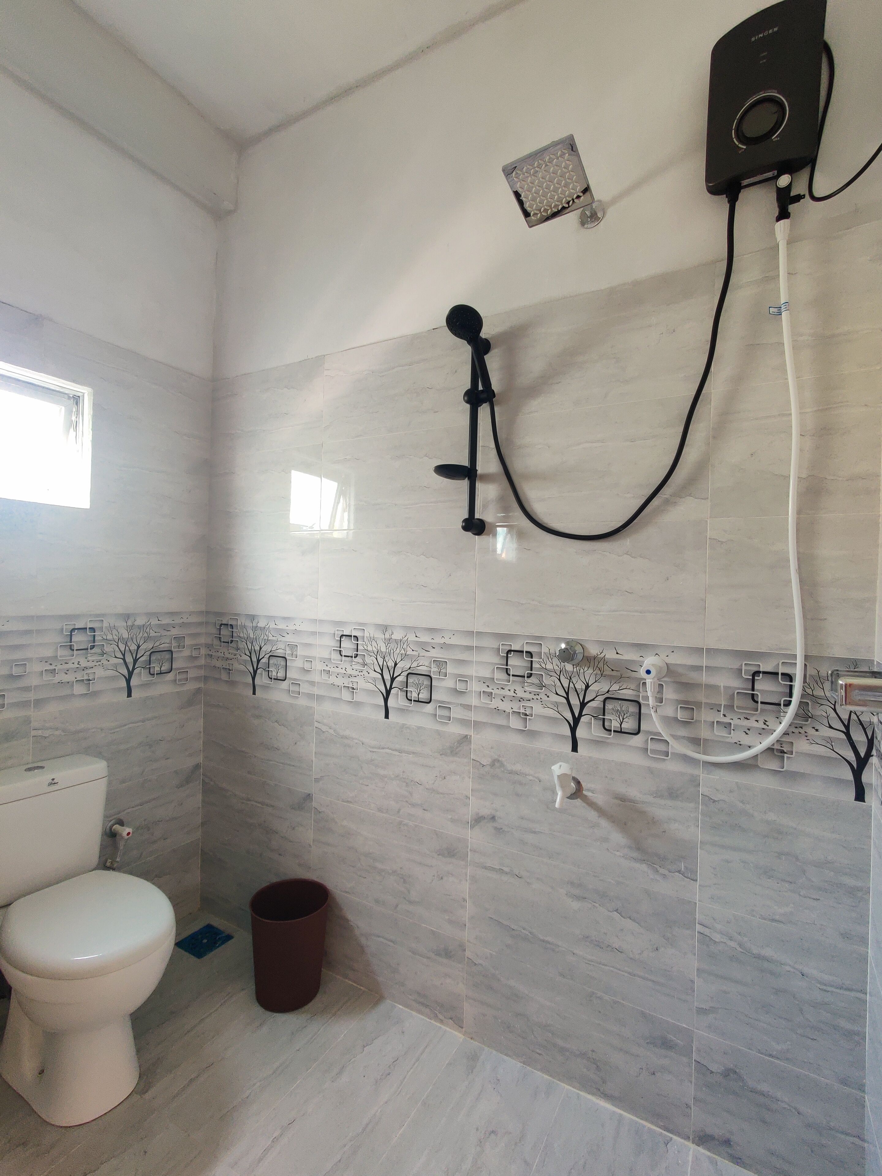 A bathroom with a toilet, a shower, and a wall-mounted heater.