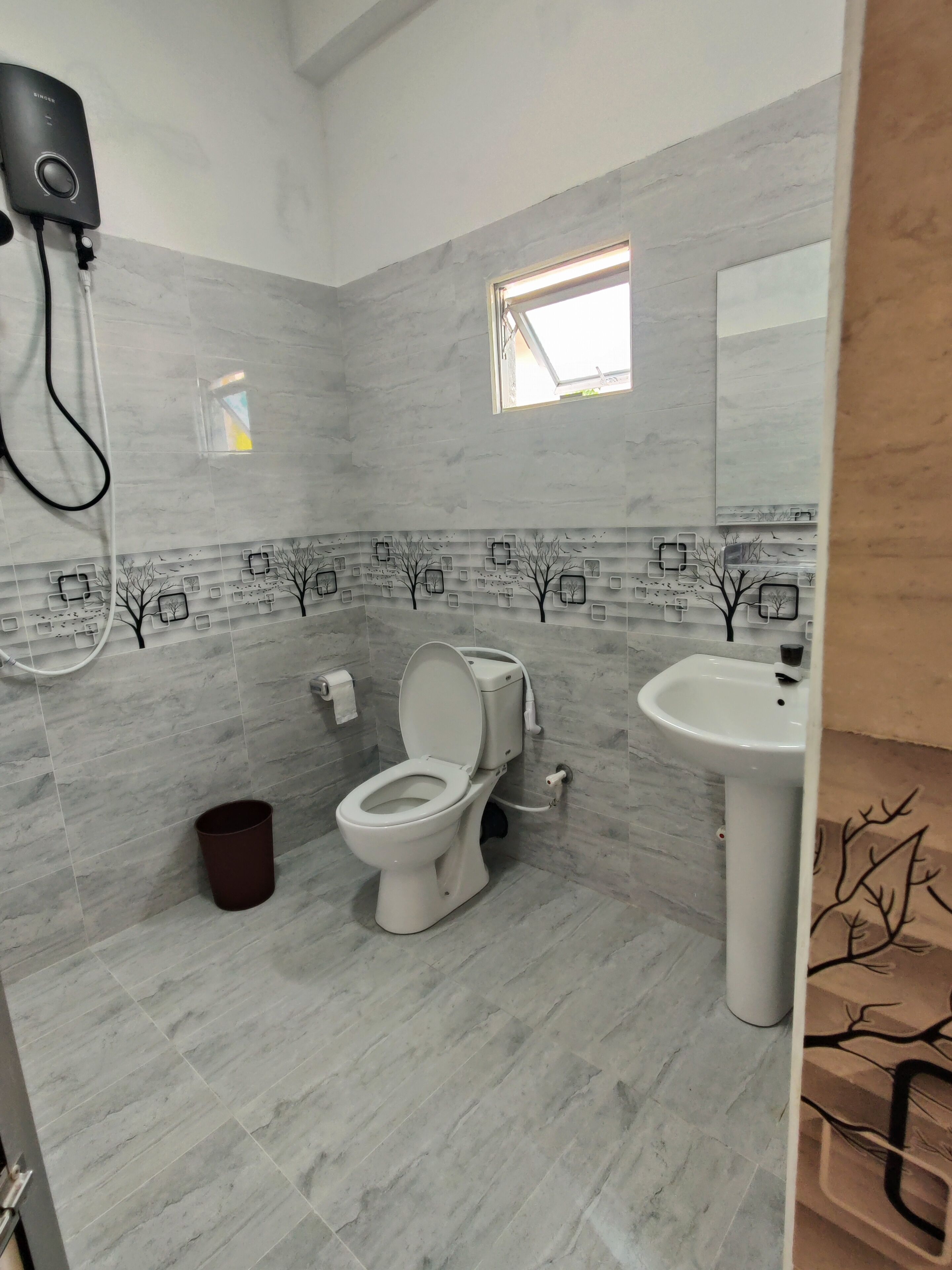 A bathroom with a toilet, sink, and a hairdryer on a wall.