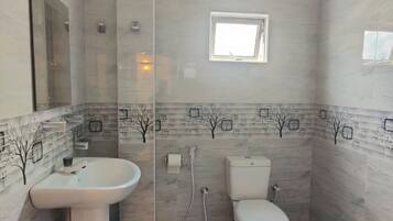 A bathroom with a sink, toilet, and shower.