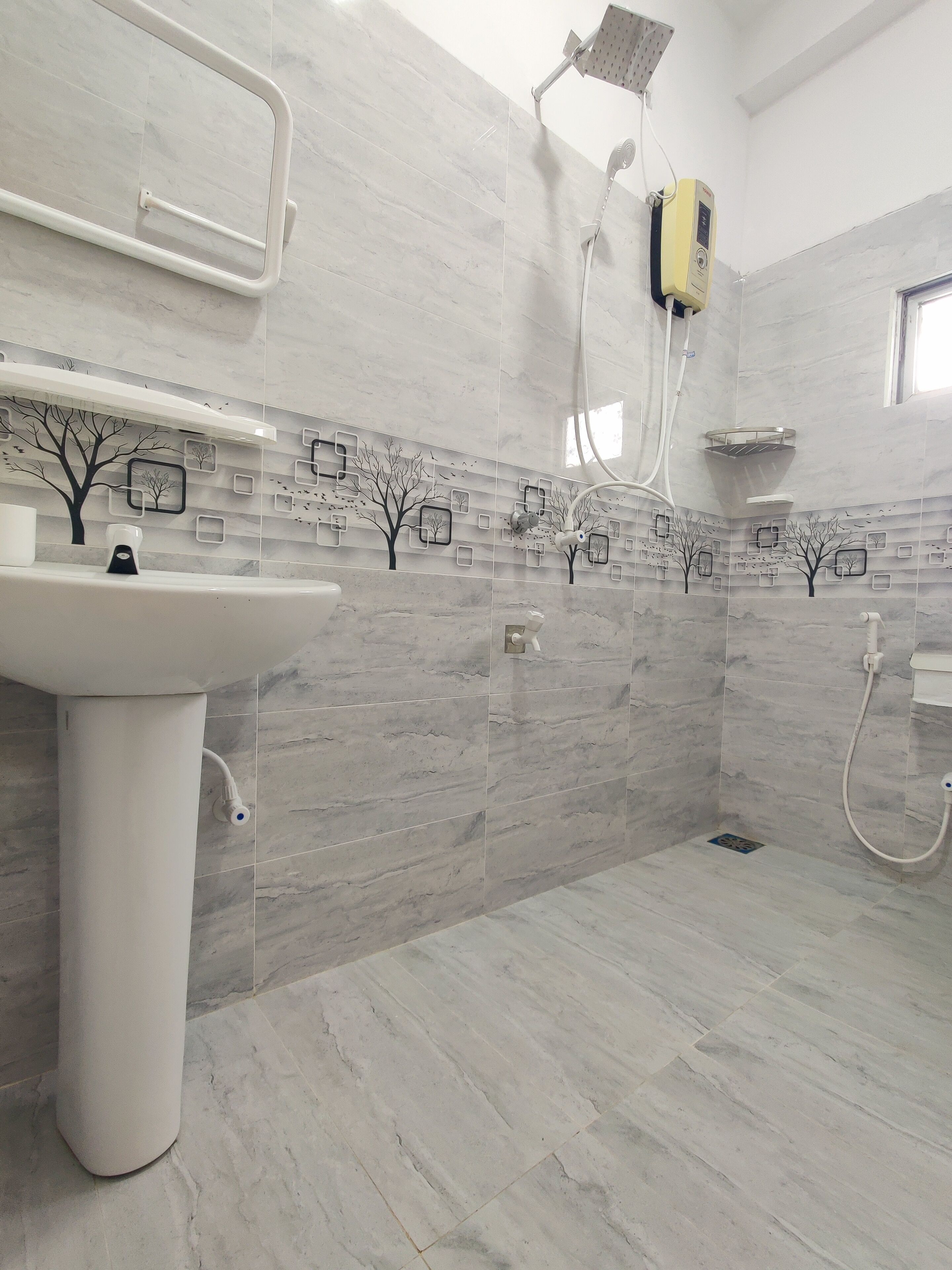 A modern bathroom with a white sink, shower, and a wall-mounted heater.