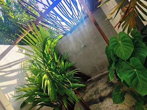 Habitación doble Confort, vista al jardín | Baño | Regadera, regadera tipo lluvia, toallas, jabón 