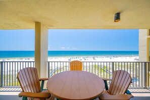 Un espace extérieur abrité, aménagé avec des sièges, et offrant une vue sur une plage et l’océan.