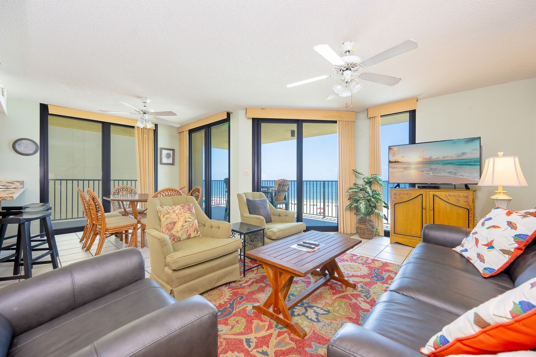 A spacious living area with a sofa, chairs, a coffee table, and a television.