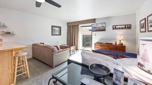 Ein Hotelzimmer mit Bett, einer Couch, einem Essbereich und einem Fernseher.